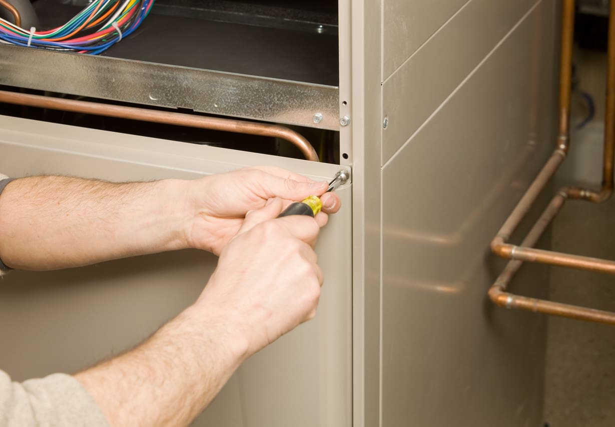 Technician Removing Service Panel of Furnace